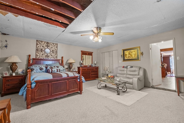 bedroom featuring light carpet, a textured ceiling, and ceiling fan