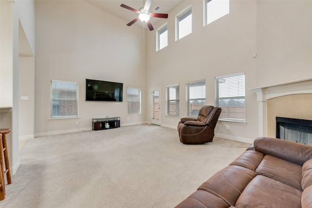 living room featuring a fireplace, ceiling fan, and carpet flooring