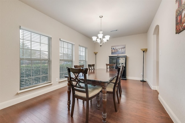 dining room with dark hardwood / wood-style flooring and a notable chandelier