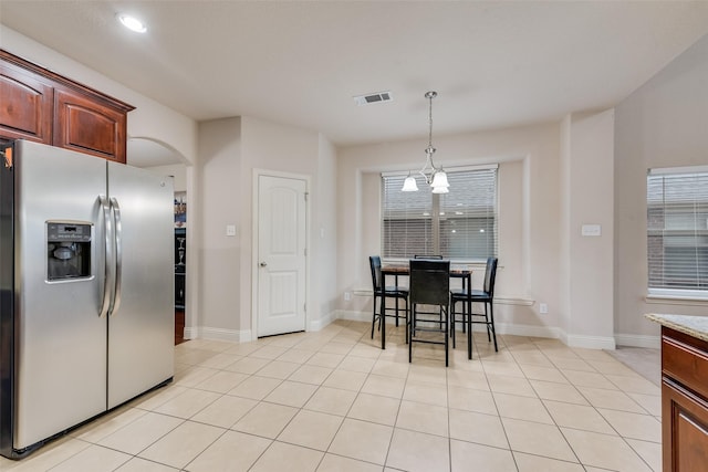 kitchen with light tile patterned floors, decorative light fixtures, a notable chandelier, and stainless steel refrigerator with ice dispenser