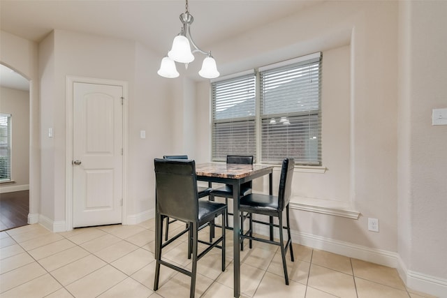 dining area featuring light tile patterned floors and a notable chandelier