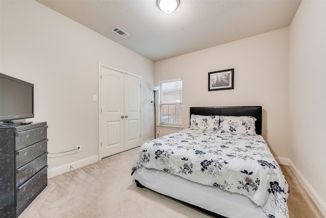 bedroom with carpet floors, a textured ceiling, and a closet