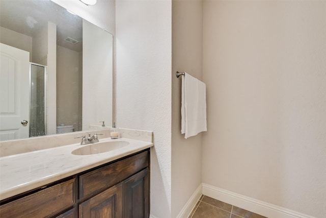 bathroom with vanity, tile patterned floors, toilet, and walk in shower