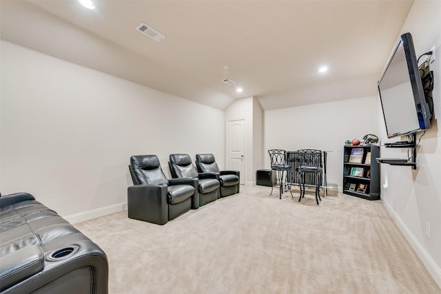 carpeted home theater room with vaulted ceiling