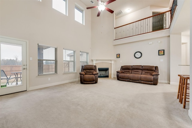 carpeted living room with ceiling fan