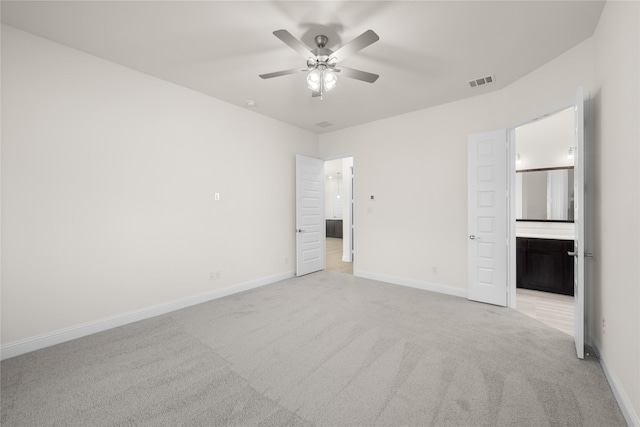 unfurnished bedroom featuring light carpet, ensuite bath, and ceiling fan