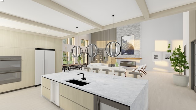 kitchen with white built in refrigerator, sink, hanging light fixtures, beam ceiling, and cream cabinetry