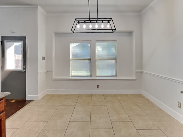 unfurnished dining area featuring crown molding and light tile patterned floors