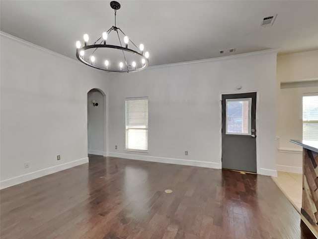 unfurnished dining area with an inviting chandelier, crown molding, and dark wood-type flooring