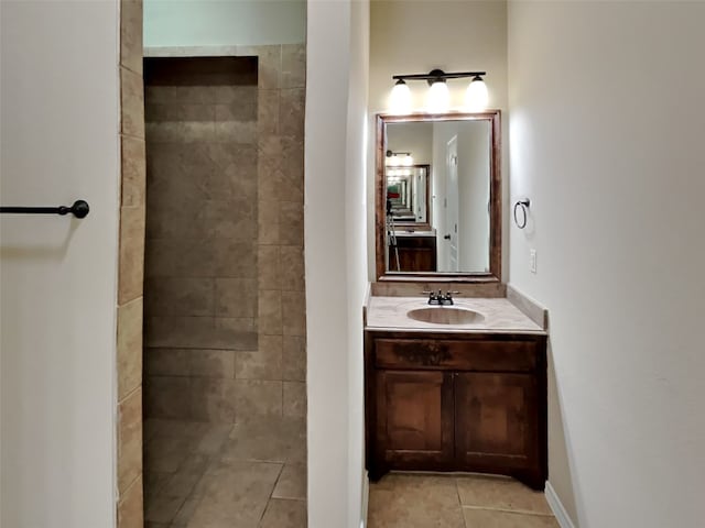 bathroom featuring tile patterned flooring, vanity, and tiled shower