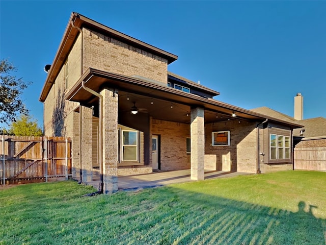 rear view of house featuring a yard, ceiling fan, and a patio area