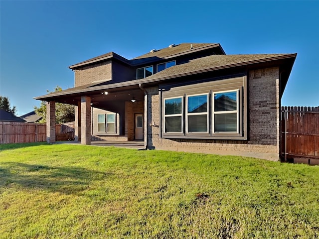 rear view of property featuring a lawn