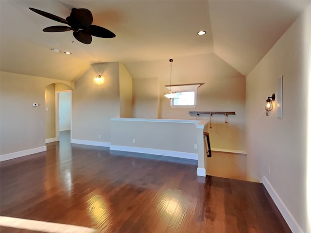 unfurnished living room featuring lofted ceiling, dark hardwood / wood-style floors, and ceiling fan