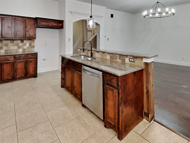 kitchen featuring sink, crown molding, hanging light fixtures, light stone countertops, and stainless steel dishwasher