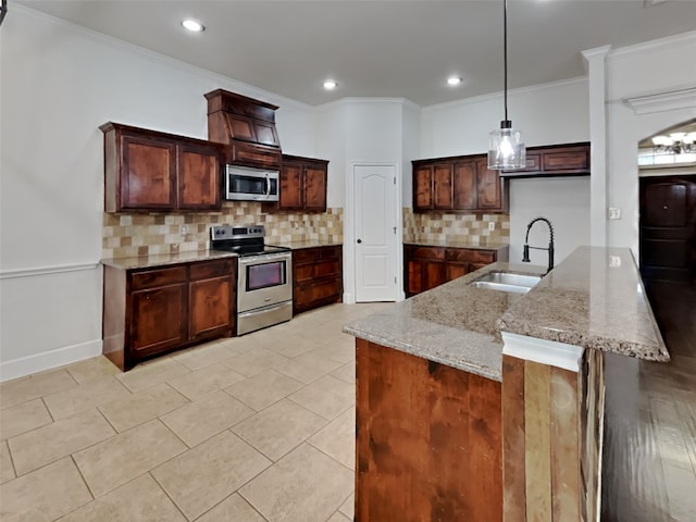 kitchen with pendant lighting, sink, stainless steel appliances, light stone counters, and ornamental molding