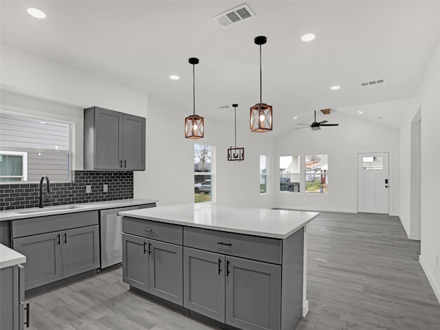 kitchen featuring stainless steel dishwasher, gray cabinets, and sink