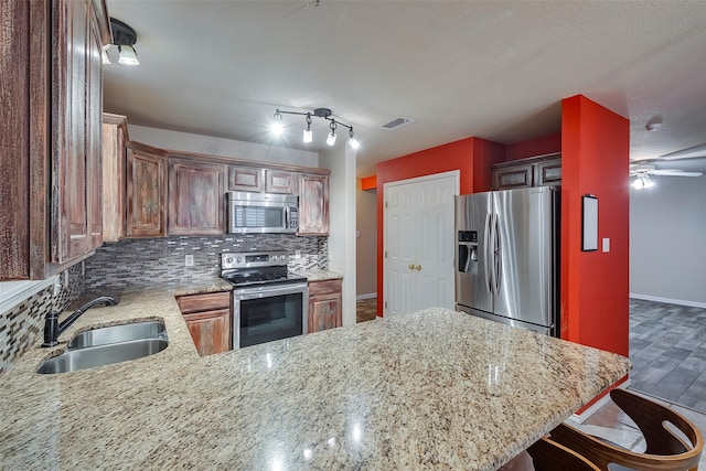 kitchen featuring a breakfast bar, sink, tasteful backsplash, kitchen peninsula, and stainless steel appliances