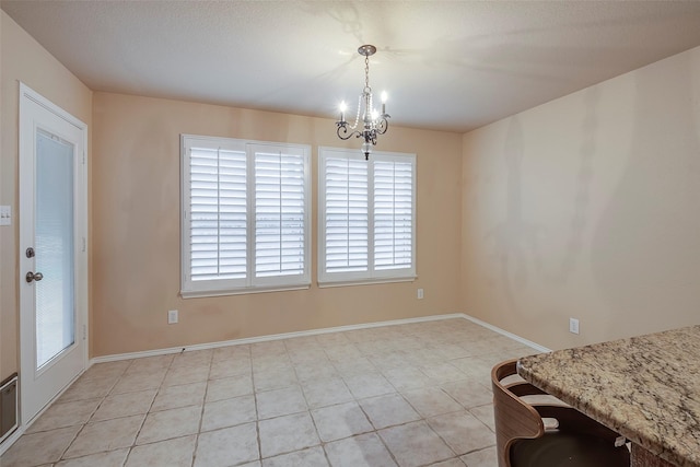 unfurnished dining area with a chandelier and light tile patterned floors