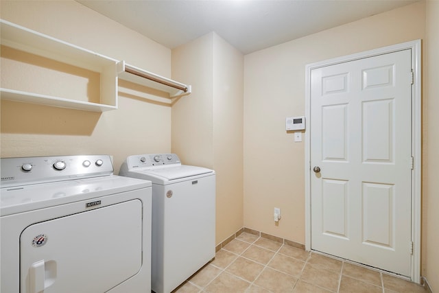 laundry room featuring light tile patterned flooring and washing machine and clothes dryer