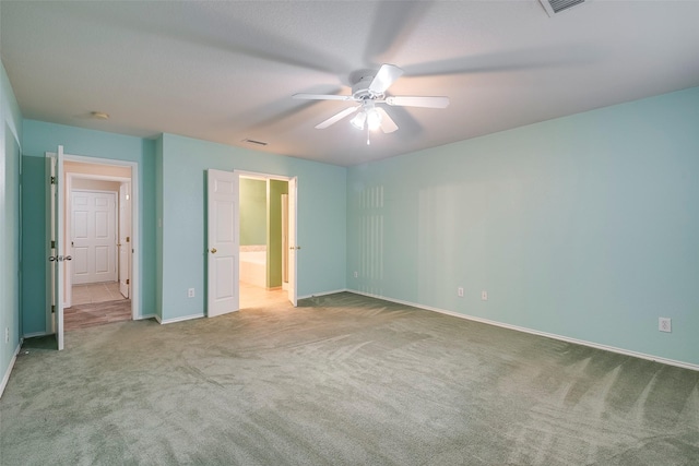 unfurnished bedroom with ensuite bathroom, light carpet, and ceiling fan