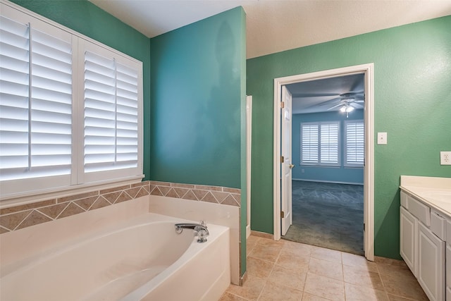 bathroom featuring ceiling fan, vanity, a bathing tub, and tile patterned flooring