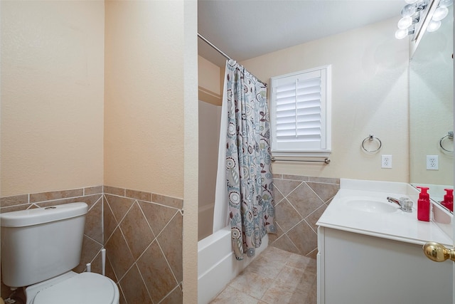 full bathroom featuring tile walls, tile patterned flooring, vanity, toilet, and shower / bath combo with shower curtain