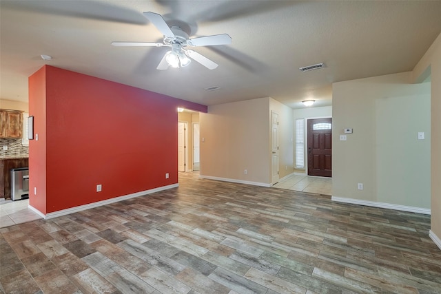 unfurnished living room featuring hardwood / wood-style flooring and ceiling fan