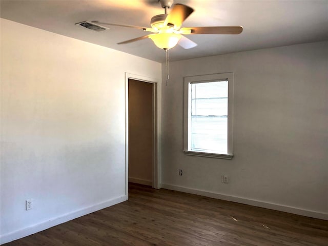 empty room featuring dark wood-type flooring and ceiling fan