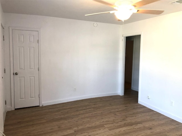 spare room with dark wood-type flooring and ceiling fan