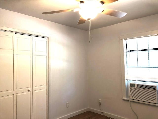 unfurnished bedroom with ceiling fan, cooling unit, dark hardwood / wood-style flooring, and a closet