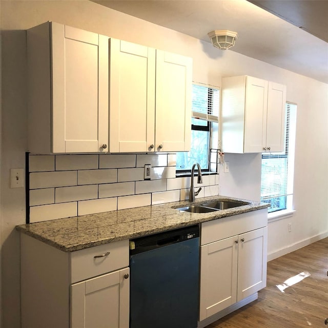 kitchen featuring hardwood / wood-style floors, black dishwasher, sink, white cabinets, and backsplash