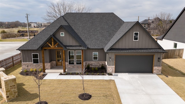 view of front of home featuring a garage, concrete driveway, roof with shingles, fence, and board and batten siding