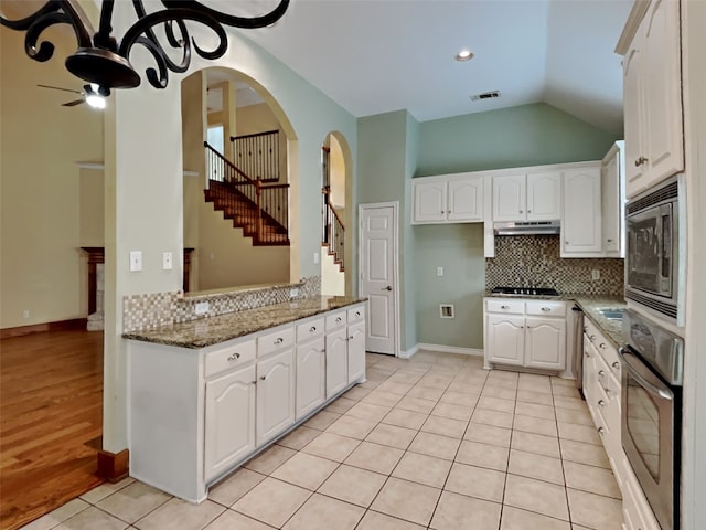 10805 Winged Foot Dr, Rowlett, TX 75089 - kitchen with stainless steel appliances, white cabinetry, dark stone countertops, and backsplash