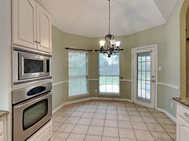 10805 Winged Foot Dr, Rowlett, TX 75089 - kitchen featuring stainless steel appliances, white cabinetry, pendant lighting, a healthy amount of sunlight, and light stone countertops