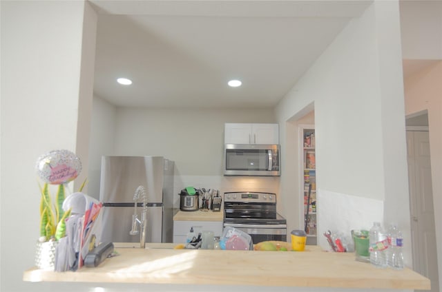 kitchen featuring white cabinetry, decorative backsplash, and appliances with stainless steel finishes