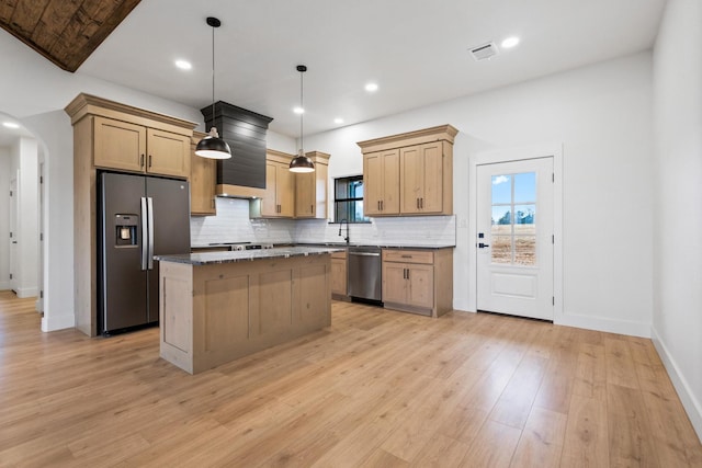 kitchen featuring sink, appliances with stainless steel finishes, tasteful backsplash, a kitchen island, and decorative light fixtures