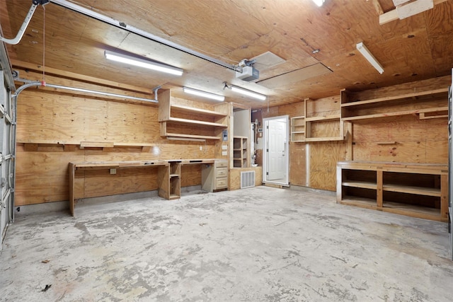 interior space with a workshop area, concrete floors, and wood walls