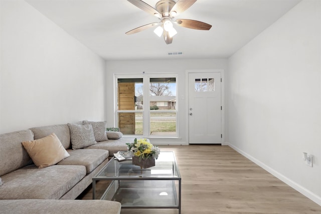 living room featuring light hardwood / wood-style flooring and ceiling fan