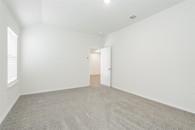 carpeted spare room with lofted ceiling