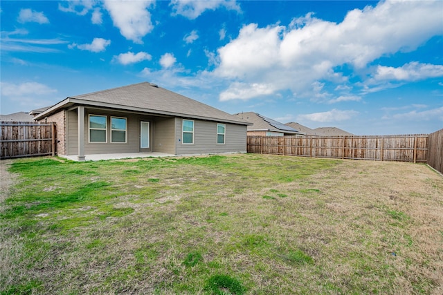 rear view of house with a yard and a patio area