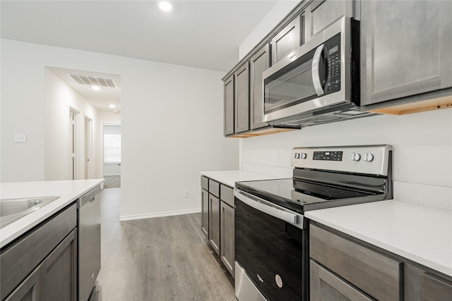 kitchen featuring stainless steel appliances and light hardwood / wood-style flooring