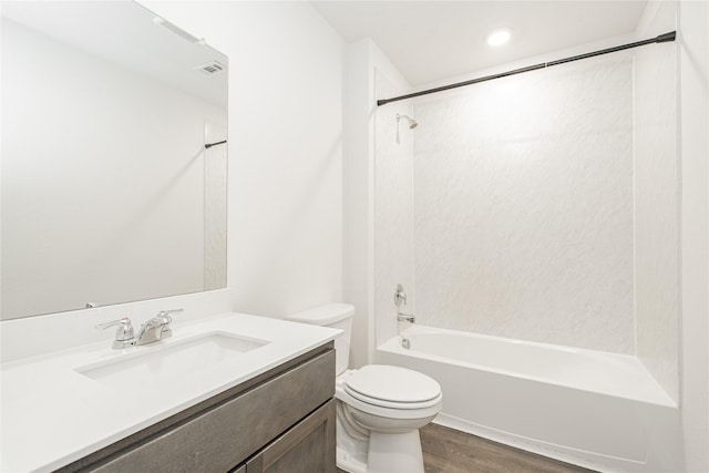 full bathroom with hardwood / wood-style flooring, tiled shower / bath, vanity, and toilet