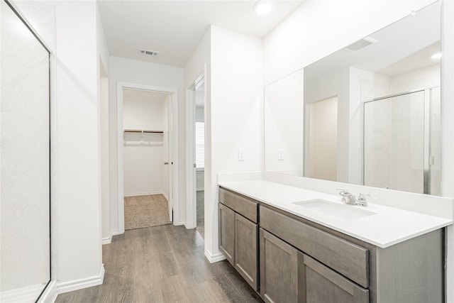 bathroom featuring vanity, hardwood / wood-style flooring, and walk in shower