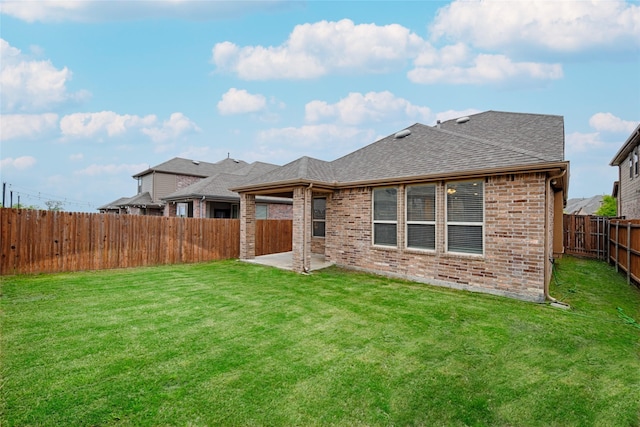 back of house with a patio area and a lawn