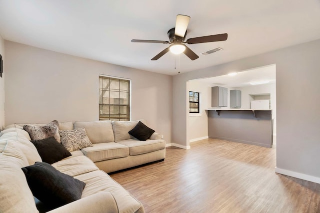 living room featuring ceiling fan and light hardwood / wood-style floors