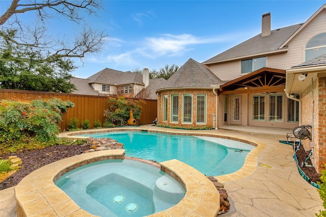 view of swimming pool featuring a fenced backyard, a pool with connected hot tub, ceiling fan, and a patio