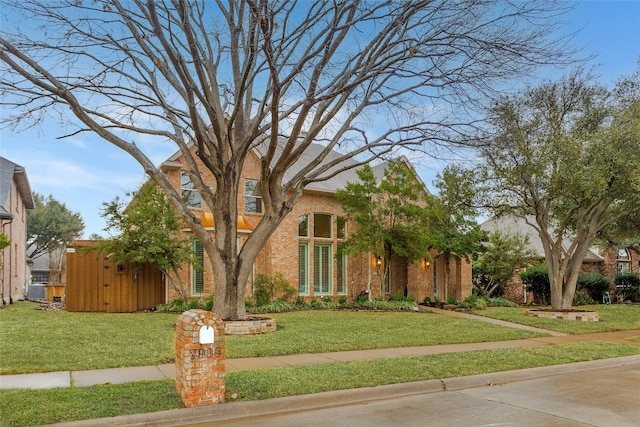 view of front of home featuring a front yard and brick siding