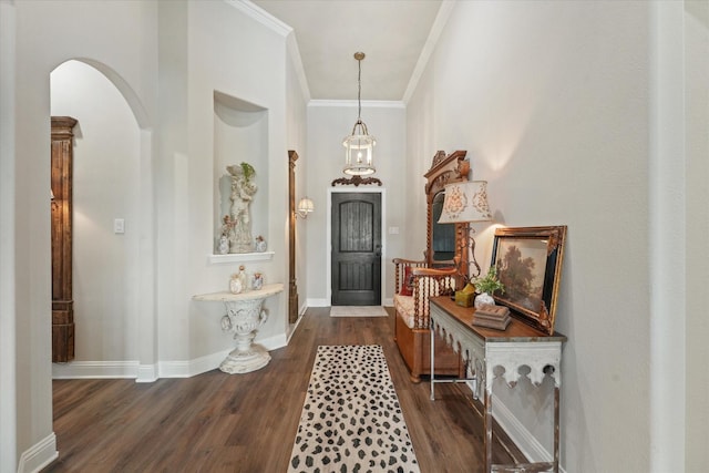 entrance foyer with dark wood-type flooring and ornamental molding