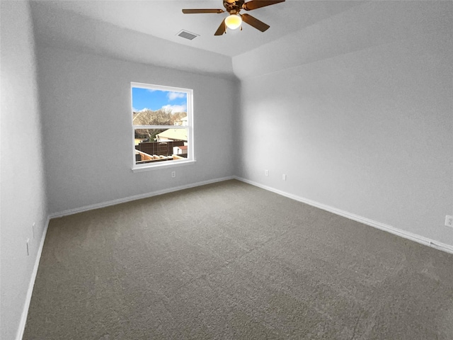 carpeted spare room featuring vaulted ceiling and ceiling fan