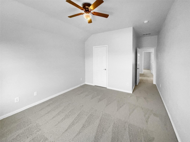 unfurnished bedroom featuring vaulted ceiling, light colored carpet, and ceiling fan